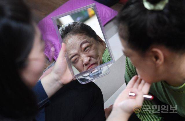 이윤정(오른쪽) 작가가 지난달 31일 작업실에서 이지현 장애인활동지원사에 도움을 받아 화장을 하고 있다.