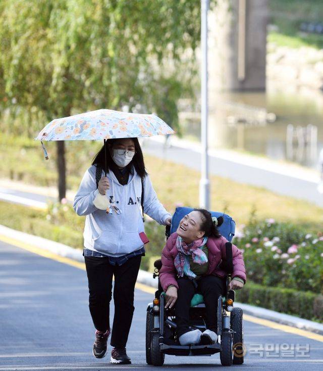이윤정(오른쪽) 작가가 지난달 31일 서울 중랑구 중랑장미공원에서 이지현 장애인활동지원사와 산책하고 있다.