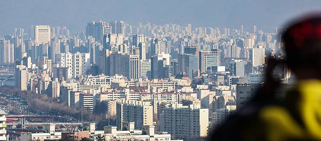 서울 남산 전망대를  찾은 시민이 강남구와 송파구 한강 근처 아파트를 바라보고 있다.  연합뉴스