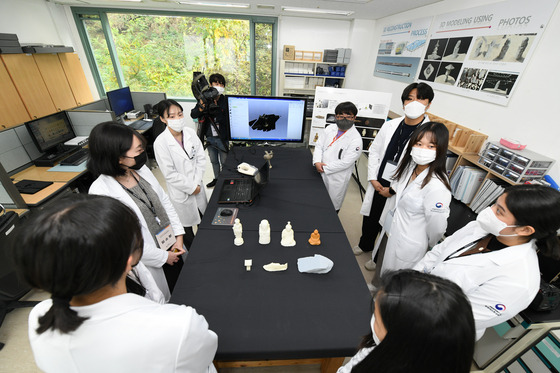 Visitors look at how 3-D scanning and 3-D printing works at the center for cultural heritages. [YIM SEUNG-HYE]