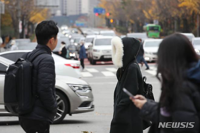 [서울=뉴시스] 권창회 기자 = 전날 내린 비로 체감온도가 뚝 떨어진 13일 오후 서울 강남구 거리에서 한 시민이 모자를 쓰고 이동하고 있다. 2022.11.13. kch0523@newsis.com