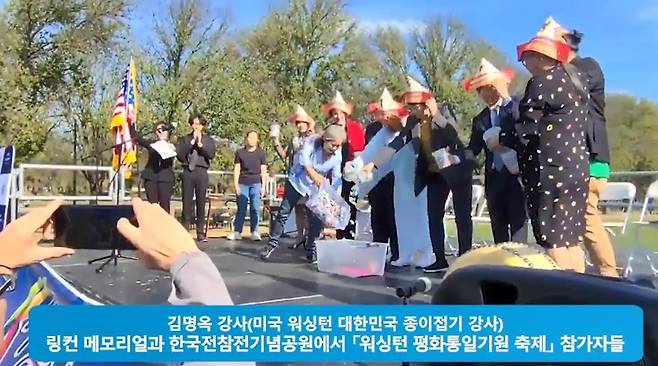 미국 워싱턴의 평화통일 기염 축제에 참여한 한인과 현지인들 고깔 합지식 장면 [줌 화면 캡처]