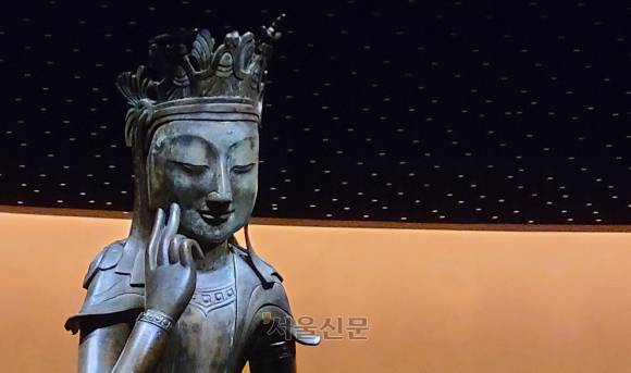 국보 78호 금동반가사유상의 미소가 돋보인다. 한 쪽 뺨에 손가락을 대고 화려한 보관을 착용했다. 천정의 디자인이 반가사유상을 위한 배경화면처럼 보인다. 강민혜 기자
