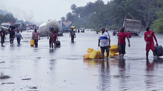지난 달 20일 폭우로 물에 잠긴 도로를 힘겹게 지나가는 나이지리아 바이엘사주 주민들. 10년 만의 최악의 홍수로 나이지리아에서 600명 이상이 숨지고, 130만명이 넘는 이재민이 발생했다. 연합뉴스