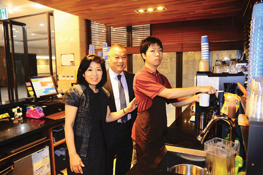 정문현 이성자씨 부부가 서울 마포구 와우산로 극동방송 신사옥에 있는 ‘조스테이블’ 커피 전문점에서 발달장애 종업원을 격려하고 있다.