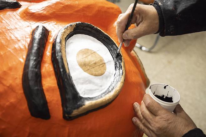 견고하게 만든 탈을 2~3일 건조하고 물감을 바른다. 정 이수자가 사자탈에 채색을 하고 있다. 붉은색은 악귀를 쫓아내는 주술적인 의미를 지니고 있다.