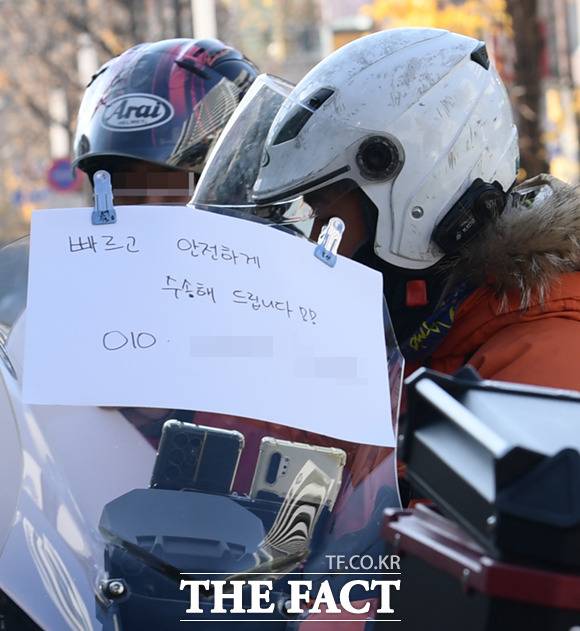 20일 오전 서울 동대문구 경희대학교에서 2023학년도 대입 수시전형 논술시험이 진행된 가운데, 퀵서비스 오토바이 기사들이 수험생을 태우기 위해 대기하고 있다. 한 오토바이 앞에 '빠르고 안전하게 수송해 드립니다'라는 문구가 붙어 있다.