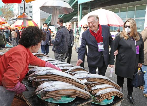 Daul Matute-Mejia, ambassador of Peru to Korea, and his wife Gabriela Blanco de Matute, speak with a local merchant at the Jagalchi Seafood Market in Busan on Saturday. [PARK SANG-MOON]