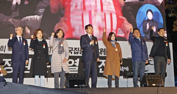 19일 오후 서울 중구 숭례문 인근에서 촛불전환행동 주최로 열린 윤석열 정부의 퇴진을 요구하는 촛불집회에서 더불어민주당 안민석 의원(가운데)이 발언하던 중 다른 의원들이 손을 들어올려 보이고 있다. 왼쪽부터 무소속 민형배 의원, 더불어민주당 양이원영 의원, 더불어민주당 강민정 의원, 더불어민주당 안민석 의원, 더불어민주당 유정주 의원, 더불어민주당 황운하 의원, 더불어민주당 김용민 의원. 2022.11.19 연합뉴스