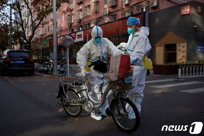21일(현지시간) 중국 베이징에서 방역 요원들이 방호복을 입고 있다. ⓒ 로이터=뉴스1 ⓒ News1 정윤영 기자