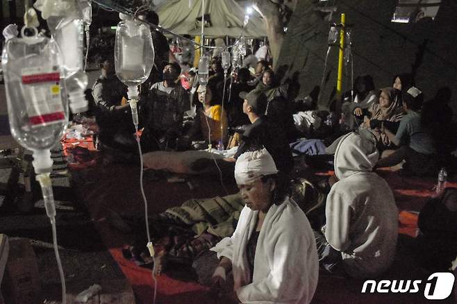 21일(현지시간) 규모 5.6의 지진이 강타한 인도네시아 치안주르에서 파괴된 병원 마당서 환자들이 치료를 받고 있다. ⓒ AFP=뉴스1 ⓒ News1 우동명 기자
