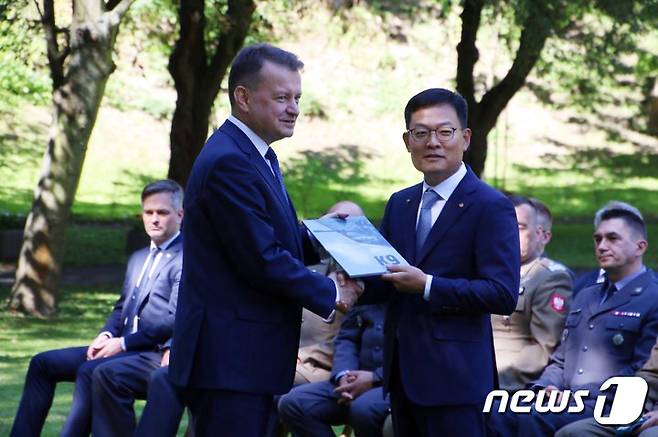 손재일 한화디펜스 대표이사(오른쪽)와 마리우시 브와슈차크 장관이 27일(현지시간) 폴란드 바르샤바에서 K9 자주포, K10 탄약운반장갑차, K11 사격지휘장갑차 등을 수출하기 위한 기본계약을 체결하고 있다. 이번 기본계약은 수출 대상 장비와 규모를 합의하는 계약이다. K9 자주포 672문 등 전체적인 공급 물량과 기간 등을 합의했다. 향후 추가적인 협상을 통해 구체적인 계약 이행사항이 담긴 실행계약을 체결할 계획이다. (한화디펜스 제공) 2022.7.28/뉴스1