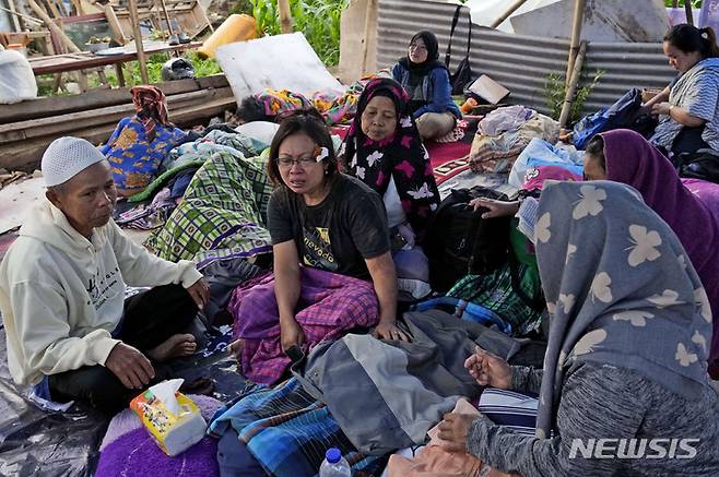 [치안주르=AP/뉴시스] 22일(현지시간) 인도네시아 서자바주 치안주르에서 한 여성이 전날 발생한 지진으로 숨진 아들의 시신 주변에서 흐느끼고 있다. 현지 당국은 규모 5.6의 지진으로 지금까지 최소 162명이 숨졌으며 사망자 수는 더 늘어날 것으로 보인다고 전했다. 2022.11.22.