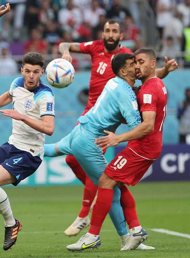 잉글랜드 해리 케인이 올린 크로스를 막아내려던 이란 골키퍼 알리레자 베이란반드와 수비수 마지드 호세이니가 충돌하고 있다. (사진=연합뉴스)