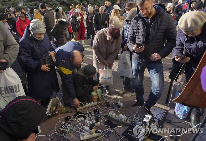 지난 15일 헤르손 중앙 광장에 모여 휴대전화를 충전하는 주민들 [AP 연합뉴스 자료사진. 재판매 및 DB 금지]