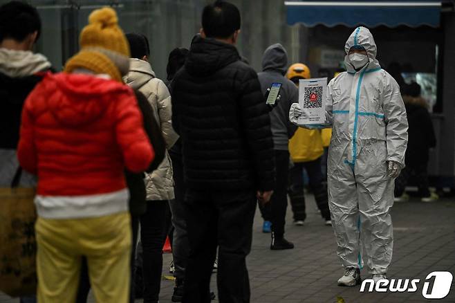 22일(현지시간) 중국 베이징의 한 코로나19 검사소에서 코로나19 검사를 받기 위해 줄을 서 있는 주민들의 모습이다.  ⓒ AFP=뉴스1 ⓒ News1 임세원 기자
