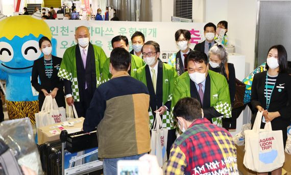 조진만 에어서울 대표와 이케다 토요히토 카가와현 지사, 오오니시 히데토 다카마쓰 시장 등이 23일 일본 다카마쓰공항에서 열린 인천~다카마쓰 노선 운항 재개 기념 행사에서 첫 편 탑승객에게 기념품을 나눠주고 있다. 사진=박범준 기자