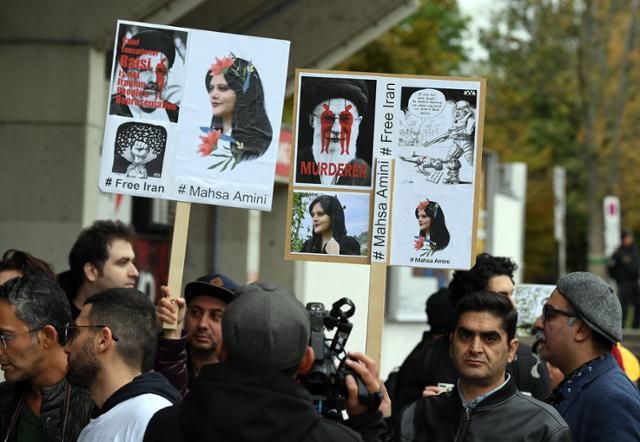 지난 9월 27일 오스트리아 뫼틀링에서 열린 이란과 세네갈의 축구 국가대표팀 친선경기를 앞두고 마흐사 아미니의 죽음에 항의하는 시위대가 시위를 벌이는 모습. AFP 연합뉴스