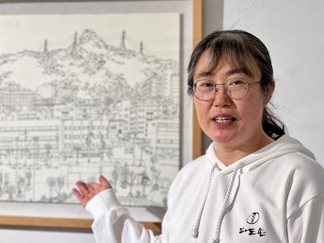 이정하 정신장애와 인권 파도손 대표가 지난 22일 서울 강남구 경애갤러리에서 파도손 쉼터가 있는 을지로 인쇄골목 전경을 그린 자신의 작품을 설명하고 있다. 그는 이곳에서는 당사자들과 지역사회가 어울려 지낸다면서 전국이 을지로 인쇄골목 같았으면 좋겠다고 설명했다. 김민호 기자
