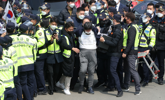 지난 3월24일 오후 대구 달성군 유가읍 박근혜 전 대통령 사저 앞에서 한 시민이 연행되고 있다. 연행되는 시민은 인사말을 하는 박근혜 전 대통령에게 소주병을 던진 것으로 알려졌다. [사진=뉴시스]