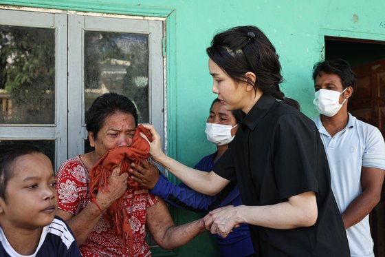 윤석열 대통령 부인 김건희 여사가 12일 캄보디아 프놈펜에서 선천성 심장질환을 앓고 있는 14세 아동의 집을 찾아 가족을 위로하고 있다.   대통령실에 따르면 이 아동의 어머니는 “12명의 자녀 중 가난으로 4명의 자녀를 잃었다"며 아들의 건강 회복을 위한 도움을 요청했다. 사진 대통령실