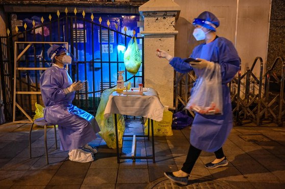 1일 상하이 징안구에서 방역 요원들이 주민들을 대상으로 핵산검사를 하고 있다. AFP=연합뉴스