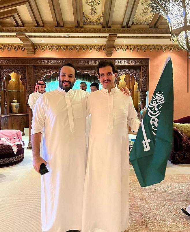 22일(현지시간) 무함마드 빈살만 사우디아라비아 왕세자(왼쪽)가 수도 리야드에서 사우디 깃발을 든 사우드 빈 살만 왕자와 함께 자국의 승리를 축하하고 있다. 로이터연합뉴스
