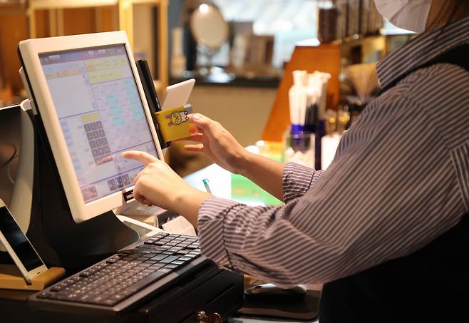 지난 3분기(7∼9월) 전체 가계 신용(빚)이 1천870조 원을 넘어 다시 역대 최대 기록을 갈아치웠다. 주택 거래가 뜸하고 금리까지 오르면서 대출 잔액은 다소 줄었지만, 코로나19 사회적 거리두기 해제 이후 소비가 늘어나면서 결제 전 카드 대금이 2조 원 넘게 급증했기 때문이다. 사진은 22일 서울 시내 한 카페에서 카드 결제하는 모습. [연합]