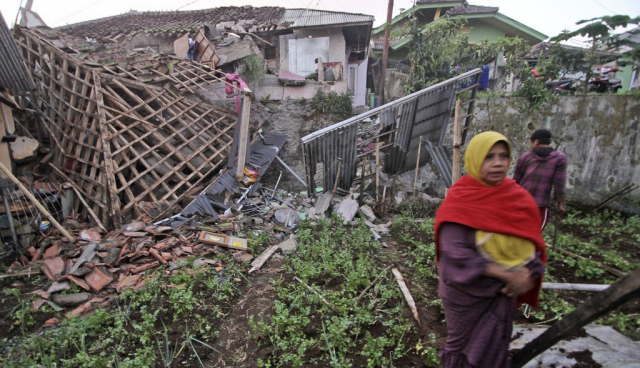 21일(현지시간) 인도네시아 서자바주 치안주르에서 발생한 지진으로 파손된 집 앞을 한 여성이 지나가고 있다. 사진=AP연합뉴스