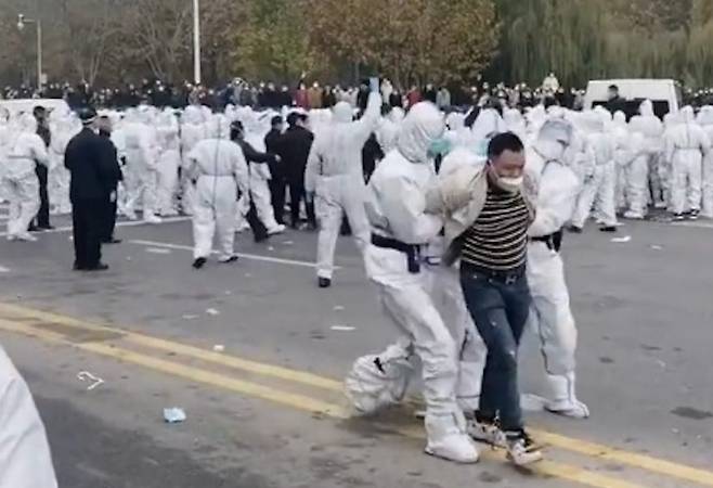 최근 시위가 벌어진 중국 폭스콘 공장에서 노동자가 끌려가고 있다./싱저우망 캡처