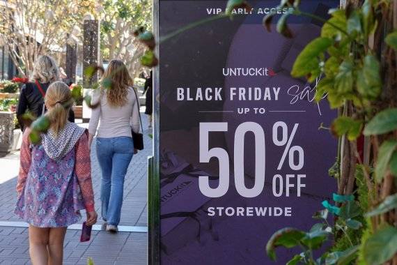 23일(현지시간) 미국 캘리포니아주 샌디에이고에서 시민들이 '블랙 프라이데이' 할인 행사를 알리는 광고판 옆을 지나고 있다.로이텨뉴스1