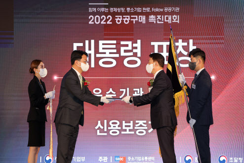 김충배 신용보증기금 전무이사(오른쪽)가 지난 24일 ‘2022 공공구매촉진대회’에서 조주현 중소벤처기업부 차관으로부터 공공구매 유공 대통령 표창을 받고 있다. 사진=신용보증기금.