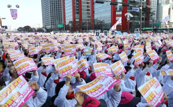 민주노총 서비스연맹 전국학교비정규직노동조합 조합원들이 25일 오후 서울 영등포구 여의대로에서 열린 '전국학교비정규직노동자 총파업대회'에서 민중의례를 하고 있다. /사진=뉴시스