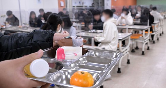 학교비정규직노동자들이 정규직과 임금 차별 해소 등을 요구하며 총파업에 돌입한 가운데 25일 서울의 한 중학교에서 학생들이 급식 대신 샌드위치와 머핀 등 대체 급식을 받아가고 있다. 사진공동취재단