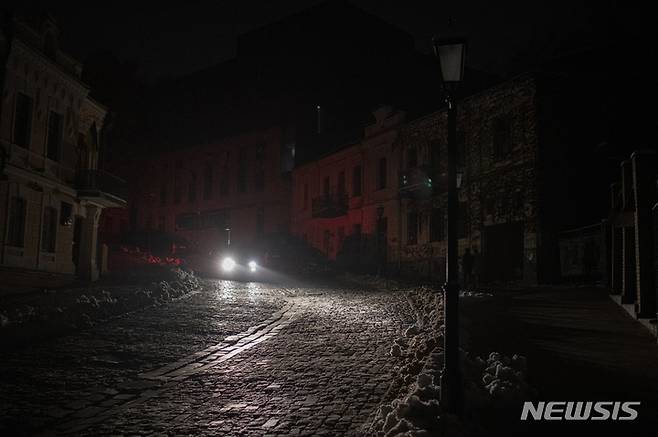 [AP/뉴시스] 23일 러시아의 미사일 일제 공격으로 많은 도시가 정전이 된 가운데 수도 키이우도 컴컴해져 차량 한 대가 어둠을 헤쳐가고 있다