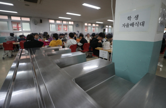 학교 비정규직 노동자들의 파업이 진행된 25일 급식이 중단된 울산의 한 초등학교에서 학생들이 점심으로 도시락을 먹는 가운데 급식실 배식대가 텅 비어 있다. 울산=연합뉴스