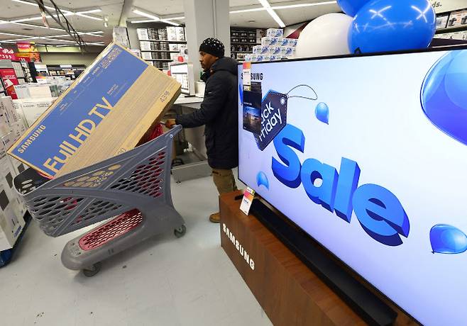 25일(현지시간) 남아프리카공화국 케이프타운의 카날 워크 몰에 있는 한 상점에서 한 쇼핑객이 블랙 프라이데이 쇼핑 중 카트에 담긴 새 텔레비전을 밀고 있다.(사진=로이터)