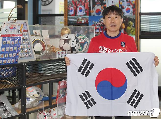 '태극기 응원맨'으로 알려진 박용식 대한민국 축구 아리랑 응원단장이 25일 자신이 운영하는 대전 서구 만년동 식당에서 월드컵 대표팀의 필승을 기원하며 태극기를 들어보이고 있다. ⓒNews1 김기태 기자