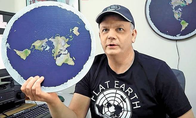 지구 평평론자들을 다룬 다큐멘터리 ‘그래도 지구는 평평하다’(2018, 원제 Behind the Curve)의 한 장면. 유튜브 등을 통해 지구 평면설을 주장하며 지구 평평론자들의 ‘왕’으로 불리는 마크 서전트가 평면 지구 패널을 들고 있다. /유튜브 ‘Behind the Curve’ 캡처
