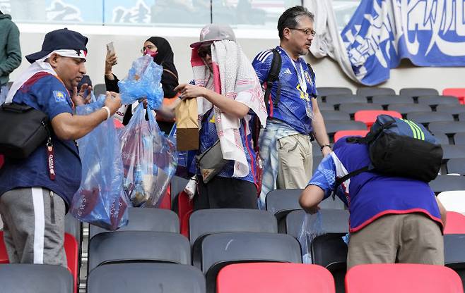 일본 축구팬들이 코스타리카와 경기를 마친 뒤 관중석 뒷정리를 하고 있다. 사진=AP PHOTO