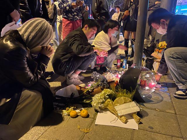 중국 상하이의 한 거리에서 26일 시민들이 지난 24일 신장웨이우얼자치구 우루무치시의 고층 아파트에 발생한 화재 사건 희생자들을 추모하고 있다. 상하이=AP 연합뉴스