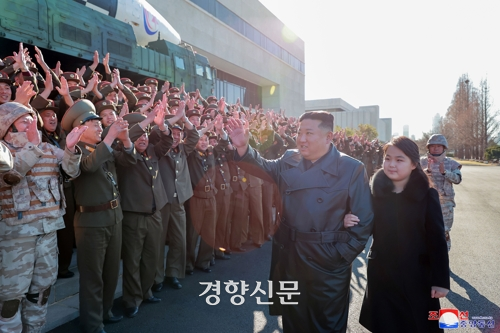 김정은 북한 국무위원장이 둘째딸과 팔짱을 낀채 ‘화성-17형’ 발사  성공 공로자들을 격려하고 있다. 조선중앙TV/연합뉴스