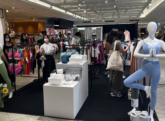 지난 7월 일본 도쿄도 루미네 쇼핑몰 신쿠주점에서 열린 젝시믹스 팝업스토어에서 방문객들이 옷을 구경하고 있다.  <사진제공=브랜드엑스코퍼레이션>