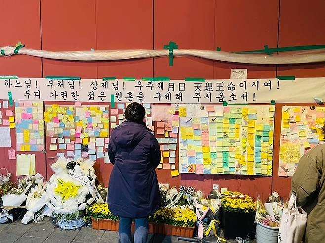이태원 참사 후 한 달여가 지난 26일 오후 참사가 발생한 서울 용산구 해밀턴 호텔 옆 골목에서 한 시민이 추모하고 있다.