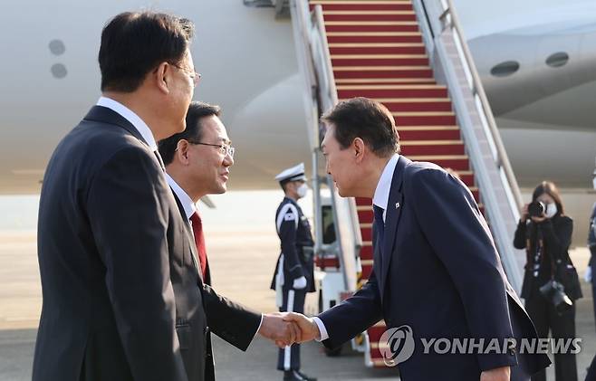 주호영 원내대표와 인사하는 윤석열 대통령 (성남=연합뉴스) 서명곤 기자 = 윤석열 대통령이 11일 오전 아세안(ASEAN·동남아국가연합) 관련 정상회의 및 주요20개국(G20) 정상회의 등 다자회의 참석을 위해 성남 서울공항에 도착, 공군 1호기로 향하며 국민의힘 정진석 비상대책위원장, 주호영 원내대표 등 환송 인사들과 악수하고 있다. 2022.11.11 seephoto@yna.co.kr