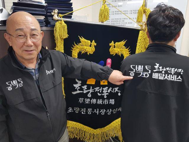 김종진 초량전통시장상인회 회장이 시장에서 배달서비스를 하고 있음을 홍보하기 위해 제작한 유니폼을 소개하고 있다.