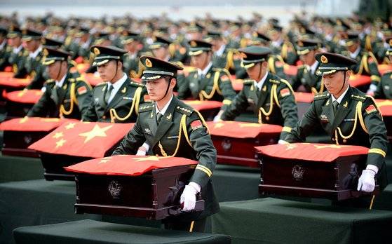 6·25전쟁 당시 전사한 뒤 우리나라에 안장됐던 중국군 유해 437구가 지난 2014년 3월 27일 중국측에 인도 됐다. 인천공항에서 열린 중국군 유해 이송 및 인도식에서 중국군이 유해에 중국 국기를 덮고 인수하고 있다. [중앙포토]