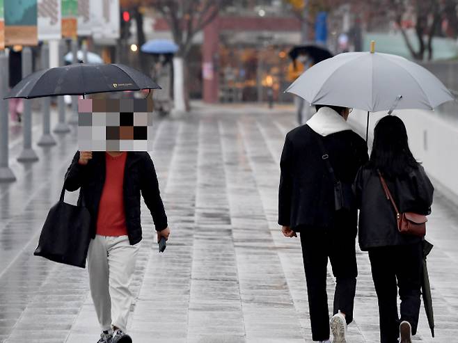 오는 29일은 전국이 대체로 흐리고 비가 내릴 것으로 예보됐다. 사진은 지난 22일 광주 동구 5·18민주광장에서 시민들이 겨울비를 피해 우산을 쓴 채 길을 걷는 모습. /사진=뉴시스