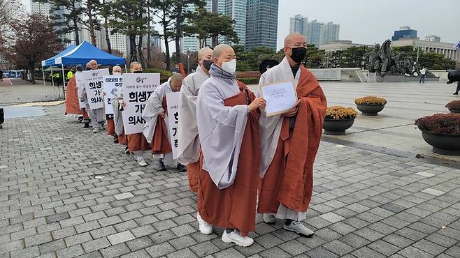 [서울=뉴시스] 대한불교조계종 사회노동위원회가 28일 오후 용산 대통령 집무실 맞은편 전쟁기념관 앞에서 '이태원 참사 한 달, 희생자 추모와 희생자 가족 의견 존중 및 소통 공간 마련 촉구 기도회'를 진행하고 있다. (사진=대한불교조계종 사회노동위원회 제공) 2022.11.28. photo@newsis.com *재판매 및 DB 금지