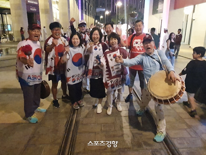 권태균 아리랑응원단장(오른쪽)이 지난 27일 카타르 도하의 미세립지구에서 동행한 단원들과 함께 ‘대~한민국’을 외치고 있다. 도하 | 황민국 기자